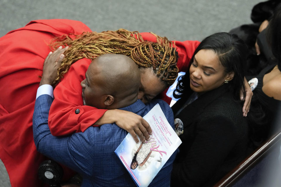 A mourner hugs Jerome Lloyd-Anderson and Dawana Davis, father and mother of Michigan State University shooting victim Arielle Anderson at a funeral in Detroit, Tuesday, Feb. 21, 2023. Anderson, Alexandria Verner and Brian Fraser and were killed and several other students injured after a gunman opened fire on the campus of Michigan State University. (AP Photo/Paul Sancya)