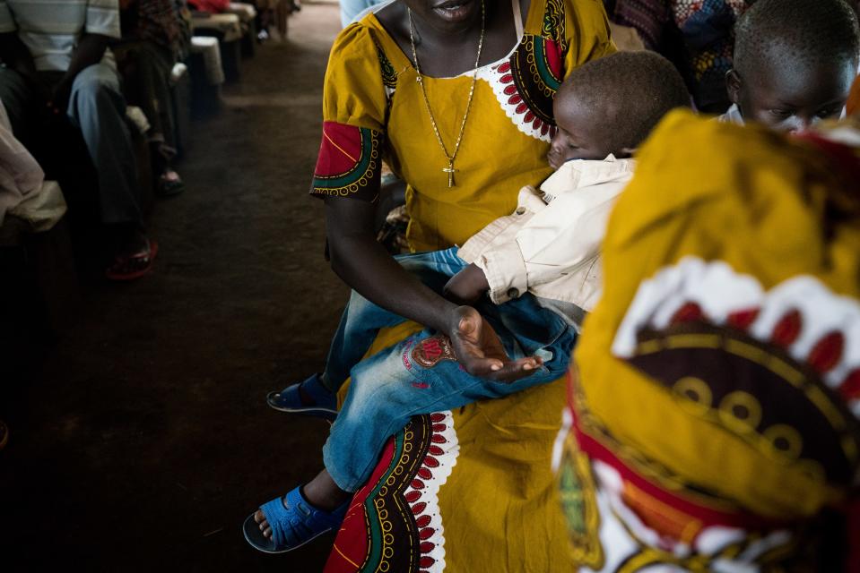 Diria sings in church as her son Abraham sleeps on her lap, June 30, 2019.