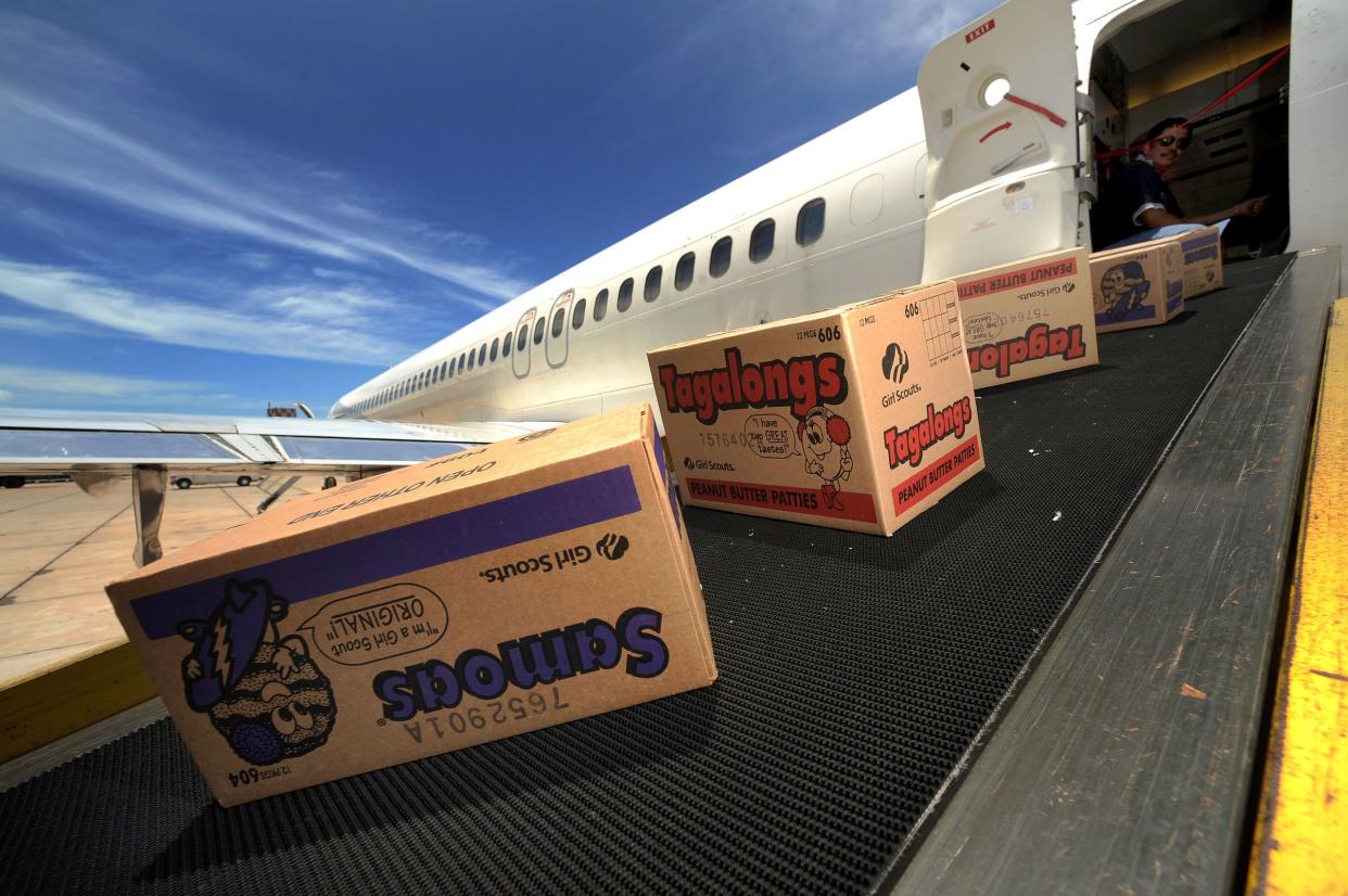 Boxes of Girl Scout Cookies Coming Out of an Airplane on a Conveyor Belt