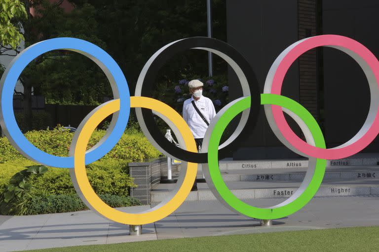 En esta fotografía del 7 de junio de 2021, un hombre camina cerca de los aros olímpicos en Tokio (AP Foto/Koji Sasahara)