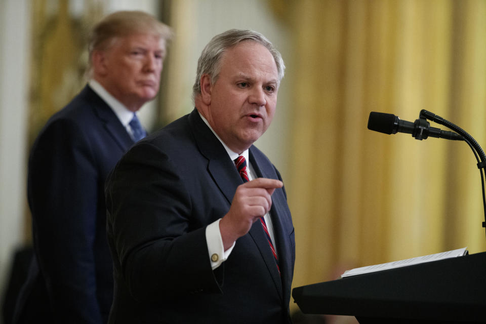 FILE - In this July 8, 2019 file photo President Donald Trump listens as Secretary of the Interior David Bernhardt speaks during an event on the environment in the East Room of the White House in Washington. A congressional committee is investigating whether the U.S. Interior Department helped an Arizona developer and supporter of President Donald Trump get a crucial permit. U.S. Rep. Raúl Grijalva is leading an investigation into the proposed 28,000-home development. Bernhardt had an unofficial meeting when he was deputy secretary with developer Mike Ingram, Arizona Diamondbacks co-owner and a prominent GOP donor. Interior officials deny politics played a part in the permit. (AP Photo/Evan Vucci, File)