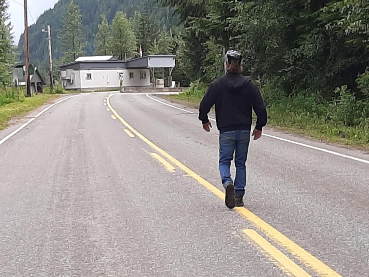 A tourist walks towards the Canada border office, at the crossing with Hyder, Alaska.  (Betsy Trumpener/CBC  - image credit)