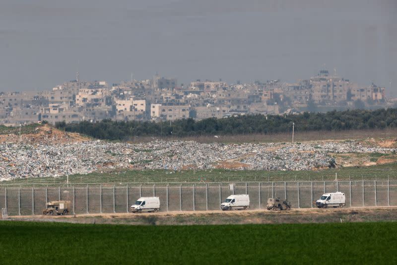 Military ambulances drive along the border fence with Gaza in Israel