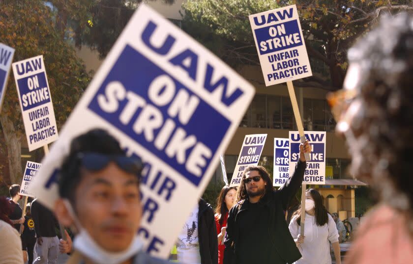 LOS ANGELES, CA - NOVEMBER 16, 2022 - - Menelik Tafari, in sunglasses, who holds a PhD from UCLA and is a research fellow at the university, joins fellow academic workers who walk the picket line at Portola Plaza on the UCLA campus in Los Angeles on November 16, 2022. Tafari is one of the organizers of the strike across all UC California campuses for better wages and benefits. His doctoral research at UCLA focuses on school design and iteration; and the integration of encounter groups, culture circles and design teams. 48,000 University of California academic workers - including postdoctoral scholars, graduate teaching assistants and researchers - walked off the job this week in a strike billed as the largest at any academic institution in history. (Genaro Molina / Los Angeles Times)