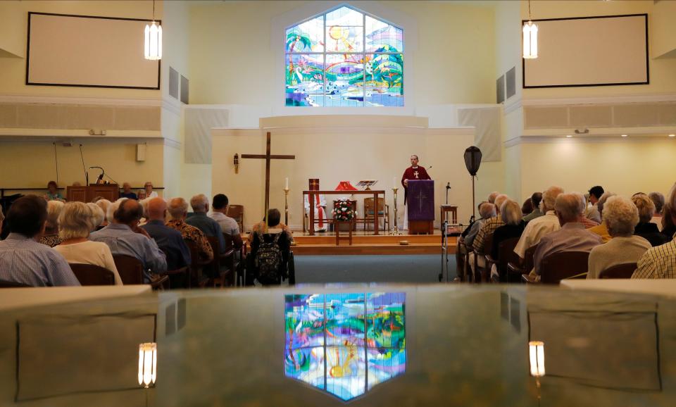 Reverend Bill Van Oss of SanibelÕs St. Michael & All Angels Churchleads a Palm Sunday service on April 2, 2023, at Fort Myers' Peace Lutheran Church. The congregation has had to conduct services at a different location after their Sanibel building was badly damaged by Hurricane Ian last year.