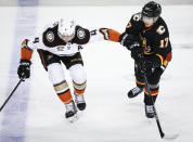 Anaheim Ducks defenceman Cam Fowler (4) holds on to Calgary Flames forward Yegor Sharangovich (17) during the third period of an NHL hockey game Tuesday, April 2, 2024, in Calgary, Alberta. (Jeff McIntosh/The Canadian Press via AP)