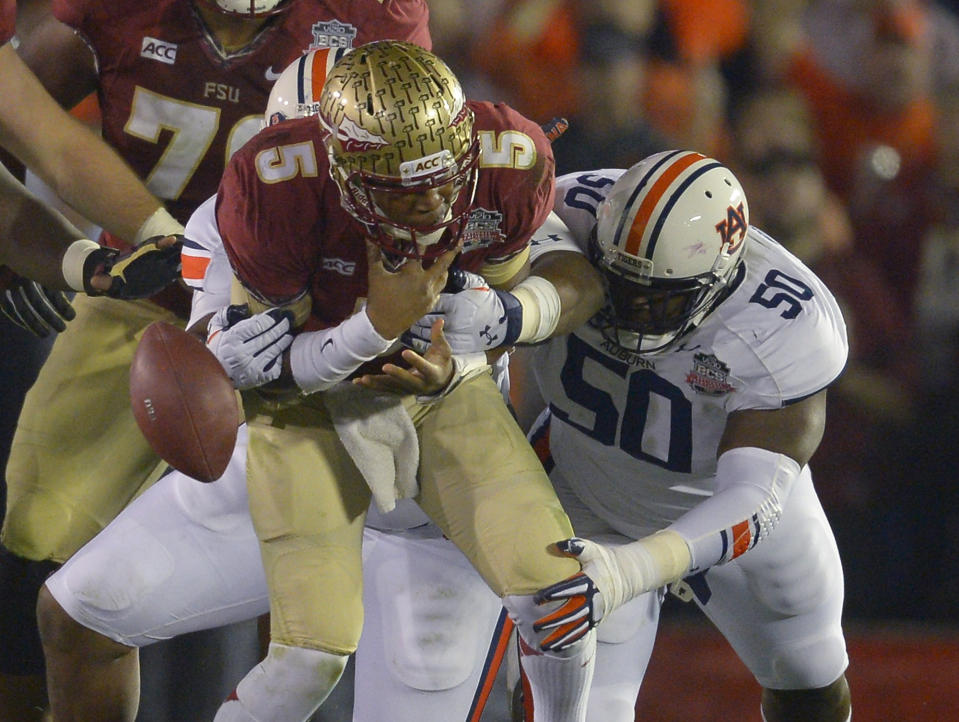 Florida State's Jameis Winston fumbles the ball as he is hit by Auburn's Ben Bradley (50)and Angelo Blackson during the first half of the NCAA BCS National Championship college football game Monday, Jan. 6, 2014, in Pasadena, Calif. (AP Photo/Mark J. Terrill)