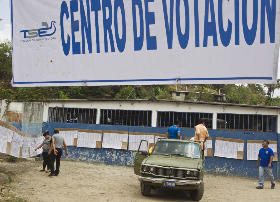 Voters search the electoral rolls for the location of their respective polling table during the presidential runoff election in Panchimalco, on the outskirts of San Salvador, El Salvador, Sunday, March 9, 2014. Salvadorans head to the polls Sunday to elect their next president in a runoff between former Marxist guerrilla Salvador Sanchez Ceren from the ruling Farabundo Marti National Liberation Front (FMLN), and former San Salvador Mayor Norman Quijano from the Nationalist Republican Alliance (ARENA). (AP Photo/Esteban Felix)