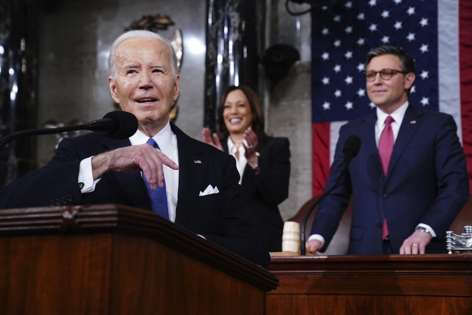 Biden smiles as he delivers his State of the Union address in front of Vice President Kamala Harris and House Speaker Mike Johnson.