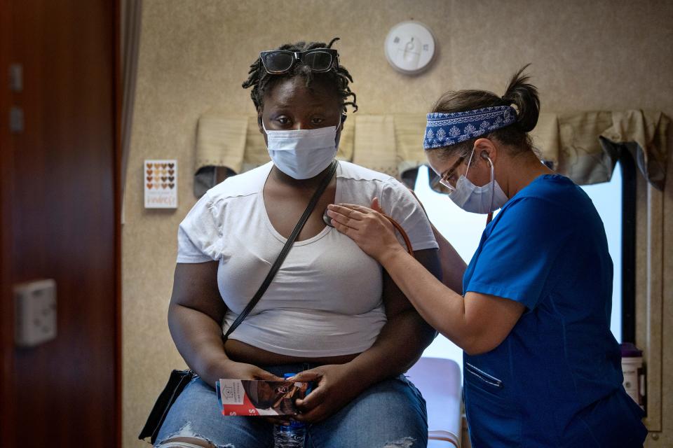 Tationa Sims, left, is check by Physician Assistant Jyoti Zaveri at the Gennesaret Free Clinic, Tuesday, May 17, 2022 on Washington St. outside the Julia M. Carson Transit Center. IndyGo has launched a pilot program, called "Wellness in Transit," providing the free mobile health clinic at the transit center operating Tuesdays in May through October. 