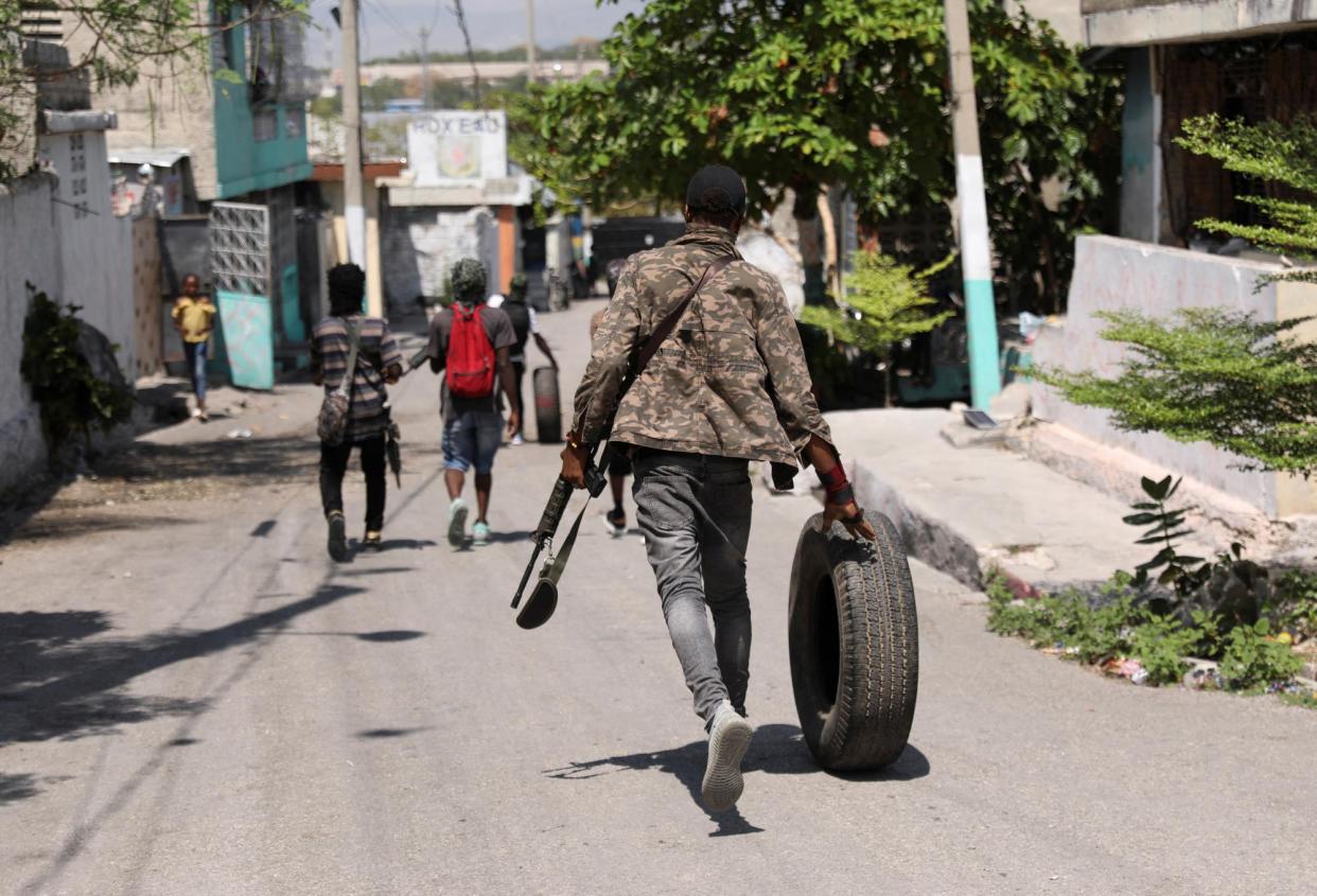 <span>A gang member walks through Port-au-Prince, Haiti, on 11 March 2024.</span><span>Photograph: Ralph Tedy Erol/Reuters</span>