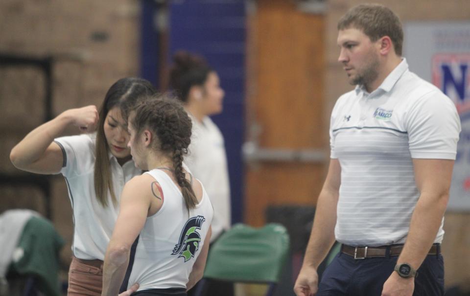 University of Providence assistant women's coach Yurie Yoneoka, left, gives Lady Argo 109-pound wrestler Lana Hunt a demonstration during an injury timeout while head coach Matt Atwood looks on Saturday during the Lady Argos' dual with Southern Oregon at McLaughlin Center. Hunt won her bout by injury default.