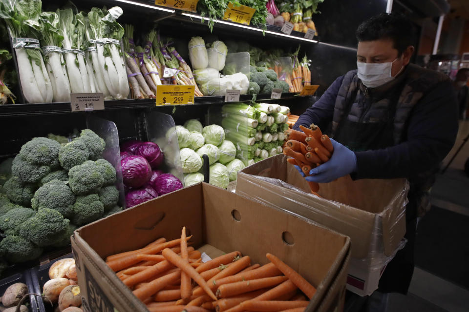 FILE - A worker stocks produce before the opening of a market in San Francisco on Friday, March 27, 2020. On Thursday, Nov. 17, 2022, U.S. agriculture officials proposed changes to the federal program that helps pay the grocery bills for pregnant women, babies and young children that includes keeping a bump in payments for fresh fruits and vegetables allowed during the COVID-19 pandemic. (AP Photo/Ben Margot, File)