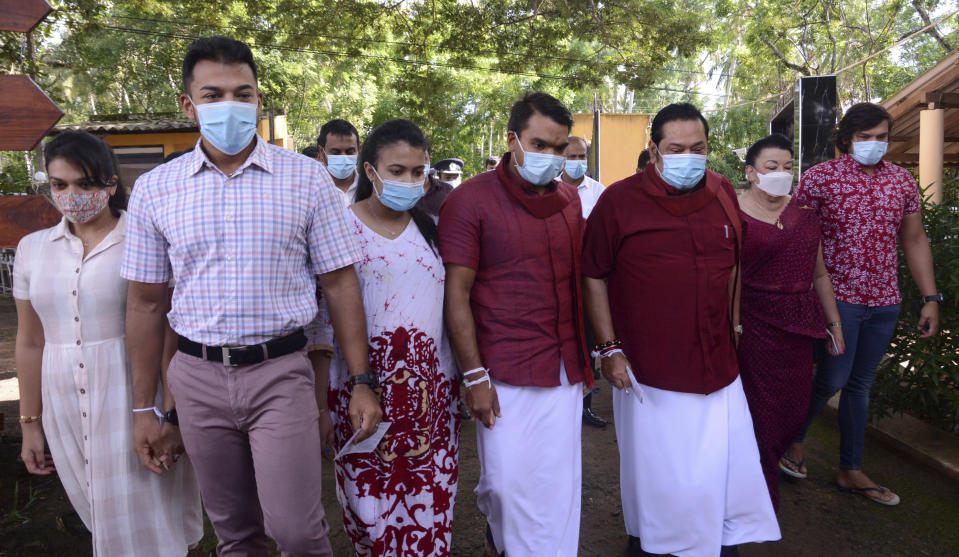 Sri Lankan Prime Minister Mahinda Rajapaksa, third right, his wife Shiranthi, second right, and family members arrive to cast their votes in their home village Madamulana, Sri Lanka, Wednesday, Aug. 5, 2020. Sri Lankans started voting Wednesday to elect a new Parliament that is expected to give strong support to the powerful and popular Rajapaksa brothers. (AP Photo/Pradeep Pathirana)