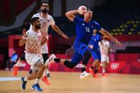 <p>France's centre back Kentin Mahe (R) jumps to shoot past Bahrain's centre back Husain Al Sayyad (L) and Bahrain's left back Ali Merza Salman Abdulla Ali during the men's quarterfinal handball match between France and Bahrain of the Tokyo 2020 Olympic Games at the Yoyogi National Stadium in Tokyo on August 3, 2021. (Photo by Franck FIFE / AFP)</p> 