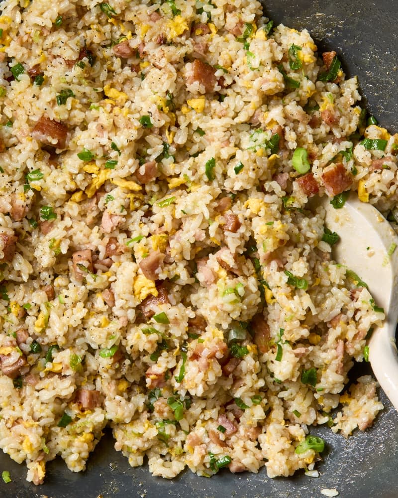 Spam fried rice in a wok with a spatula.