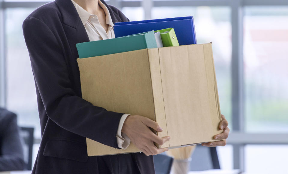 person leaving an office with a box of stuff after getting fired