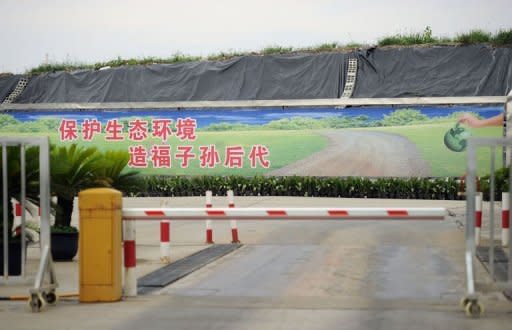 A sign in Chinese characters says "Protect the ecological enviroment for the happiness of future generations" is displayed near a garbage dump in Songjiang district. Environmental pollution and perceived health threats are sparking protests in China