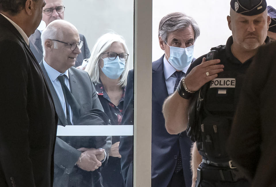 France's former Prime Minister Francois Fillon, right, and his wife Penelope wear protective masks as they arrive at Paris courthouse, in Paris, Monday, June 29, 2020. A Paris court is set to render or postpone a verdict in the fraud trial of former Prime Minister Francois Fillon on Monday. (AP Photo/Michel Euler)