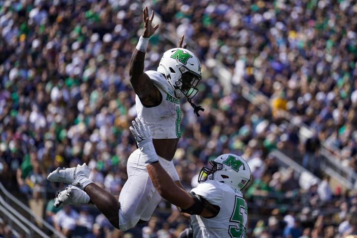 Marshall offensive lineman Ethan Driskell throws up wide receiver Cam Pedro as they celebrate a touchdown against Notre Dame during the first half of an NCAA college football game in South Bend, Ind., Saturday, Sept. 10, 2022. (AP Photo/Michael Conroy)