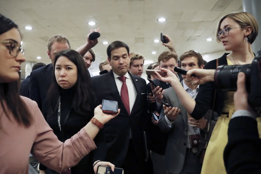 Sen. Marco Rubio, R-Fla., center, reacts while taking questions from reporters on Capitol Hill in Washington, Friday, Jan. 31, 2020, during the impeachment trial of President Donald Trump on charges of abuse of power and obstruction of Congress. (AP Photo/Julio Cortez)