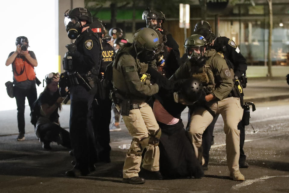 FILE - In this July 29, 2020, file photo, federal officers arrest a demonstrator during a Black Lives Matter protest at the Mark O. Hatfield United States Courthouse in Portland, Ore. An Associated Press analysis of more than 200 arrests shows that even those accused of breaking the law during the nightly rallies don’t neatly fit into President Donald Trump’s depiction of protesters as “anarchists and agitators.” (AP Photo/Marcio Jose Sanchez, File)