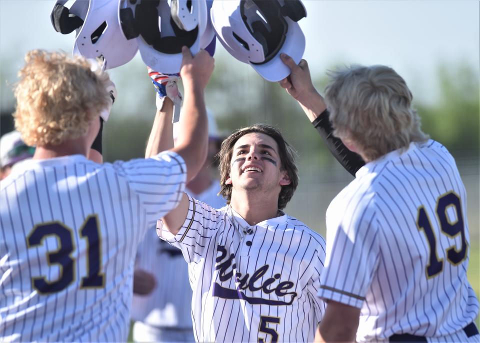 Wylie's Brady Clark (5) celebrates with Collin Bruning (31) and Sam Walker (19) after scoring on his three-run home run in the first inning. Clark's blast capped a seven-run first. Wylie beat Plainview 15-5 in six innings in the Region I-5A bi-district playoff opener May 4 at Wylie High School.