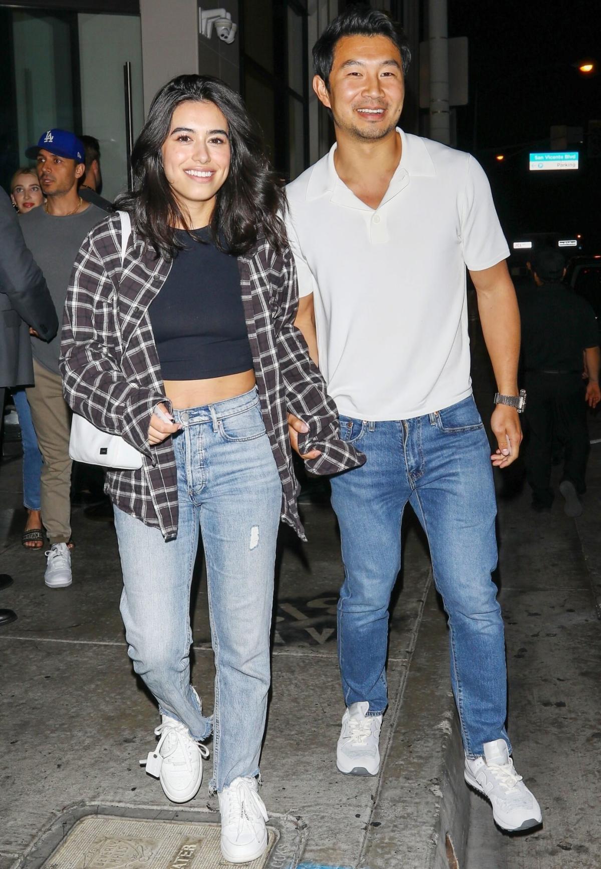 Simu Liu and girlfriend Jade Bender exchange a laugh on the red