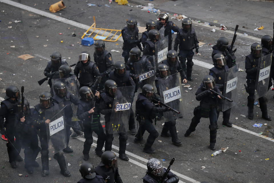 Police take position on the fifth day of protests over the conviction of a dozen Catalan independence leaders in Barcelona, Spain, Friday, Oct. 18, 2019. Tens of thousands of flag-waving demonstrators demanding Catalonia's independence and the release from prison of their separatist leaders have flooded downtown Barcelona. The protesters have poured into the city after some of them walked for three days in "Freedom marches" from towns across the northeastern Spanish region, joining students and workers who have also taken to the streets on a general strike day. (AP Photo/Manu Fernandez)