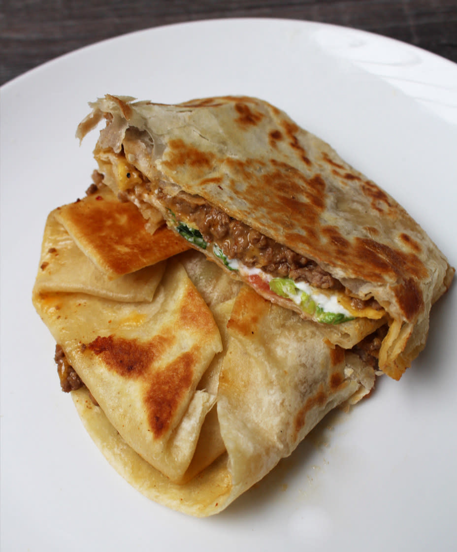 A quesadilla with melted cheese and filling on a white plate