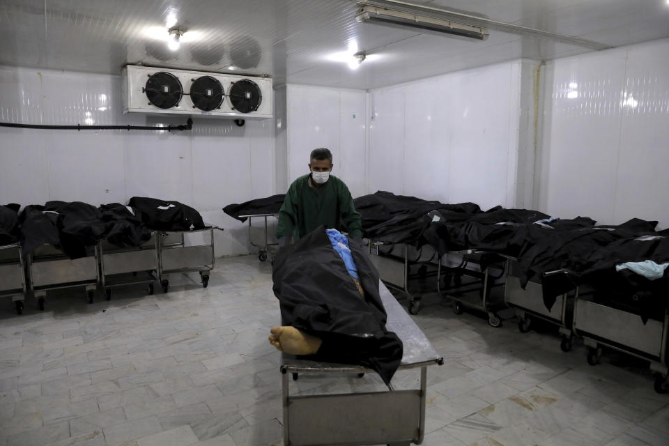 A cemetery worker prepares the body of a man who died from COVID-19, in a morgue at the Behesht-e-Zahra cemetery on the outskirts of the Iranian capital, Tehran, Iran, Sunday, Nov. 1, 2020. Mortuary attendants prepare each body for the ritual washing required for the Muslim dead. During the pandemic, that now includes the use of disinfectants. (AP Photo/Ebrahim Noroozi)