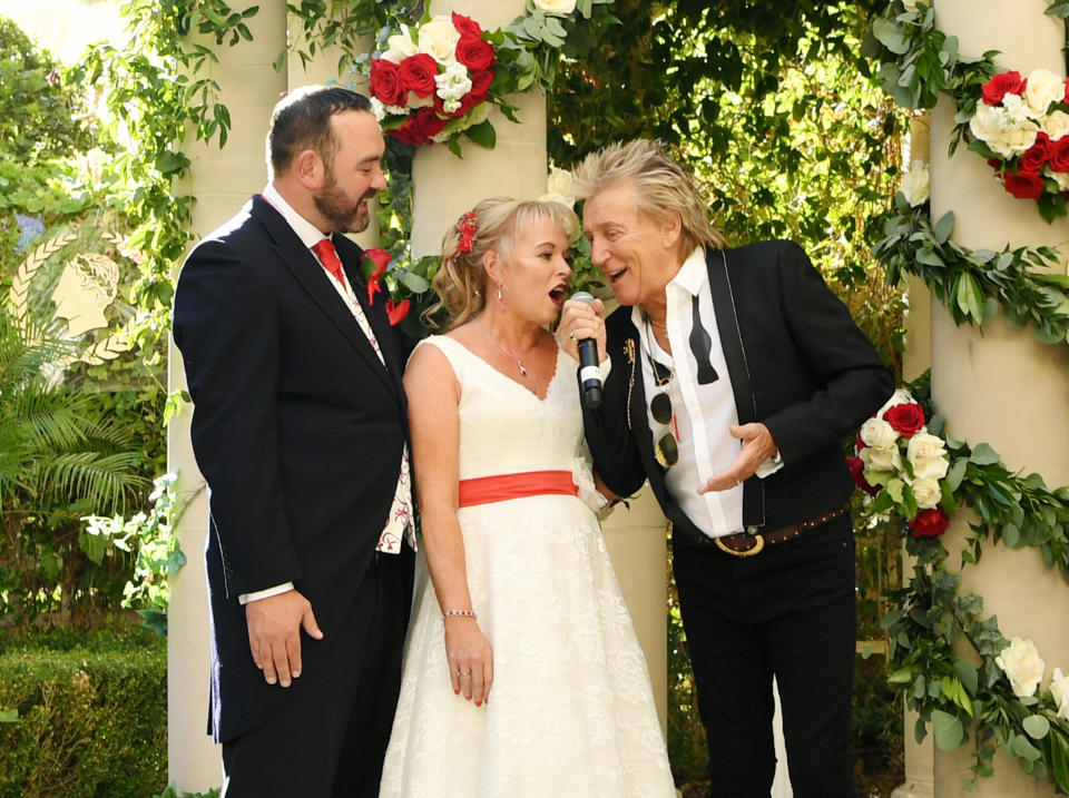 LAS VEGAS, NEVADA - OCTOBER 02: (EXCLUSIVE COVERAGE)  Sir Rod Stewart (R) sings during the wedding of Sharon Cook (C) and Andrew Aitchison (L) from Liverpool, England. The wedding was nearly cancelled due to the Thomas Cook Bankruptcy. Caesars Palace and Delta Air Lines flew the couple and their guests to Las Vegas as originally planned. The Wedding took place at Caesars Palace on October 02, 2019 in Las Vegas, Nevada. (Photo by Denise Truscello/WireImage)