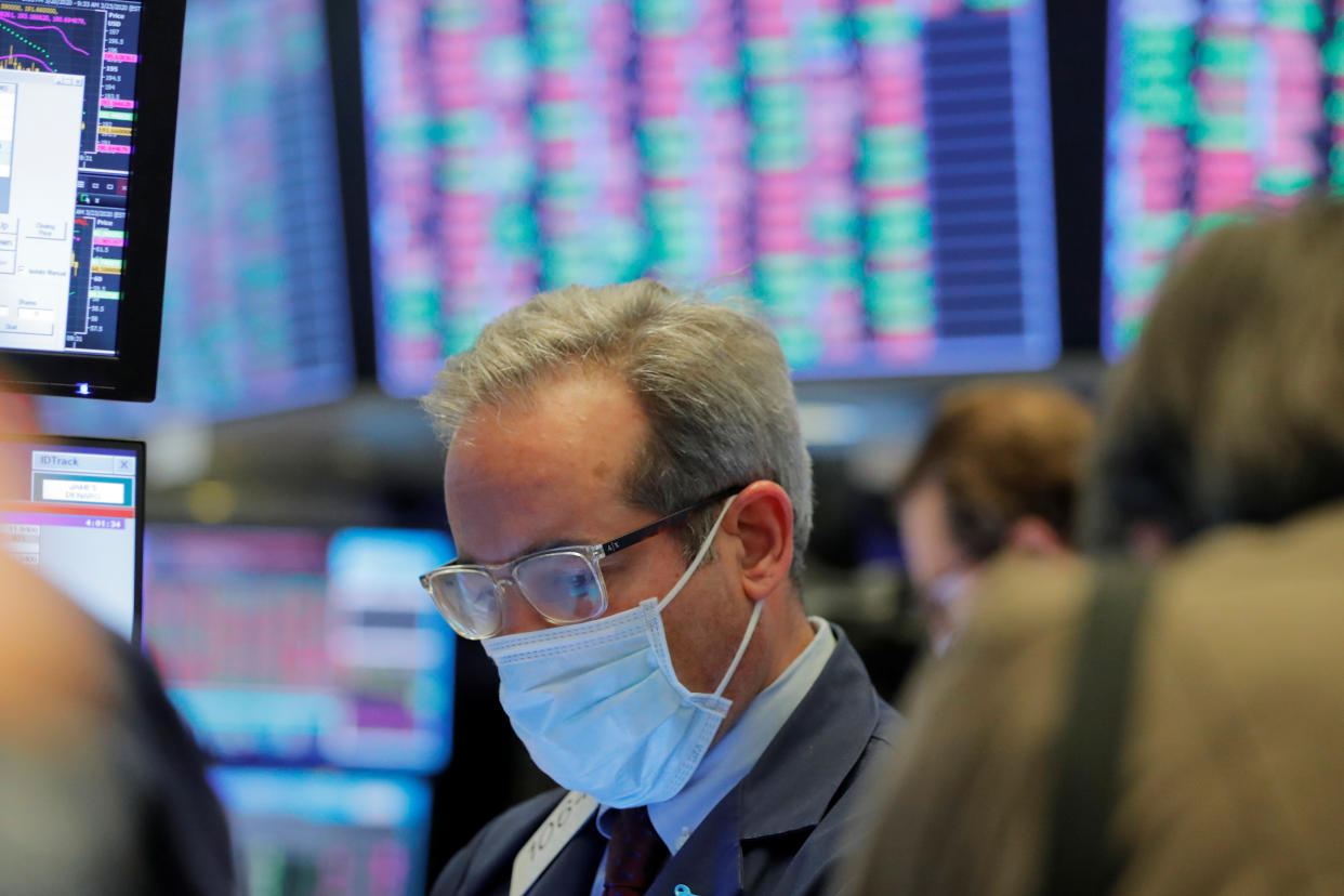 A trader wears a mask as he works on the floor of the New York Stock Exchange (NYSE) as the building prepares to close indefinitely due to the coronavirus disease (COVID-19) outbreak in New York, U.S., March 20, 2020.  REUTERS/Lucas Jackson