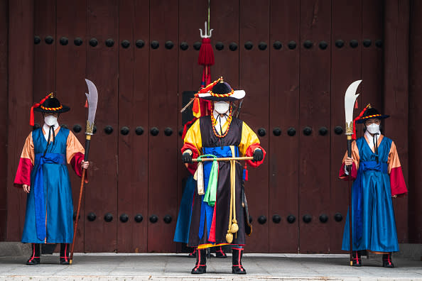 Guards of Deoksugung Palace in Seoul, South Korea, wearing face masks as a preventive measure stand at the gate of the palace.