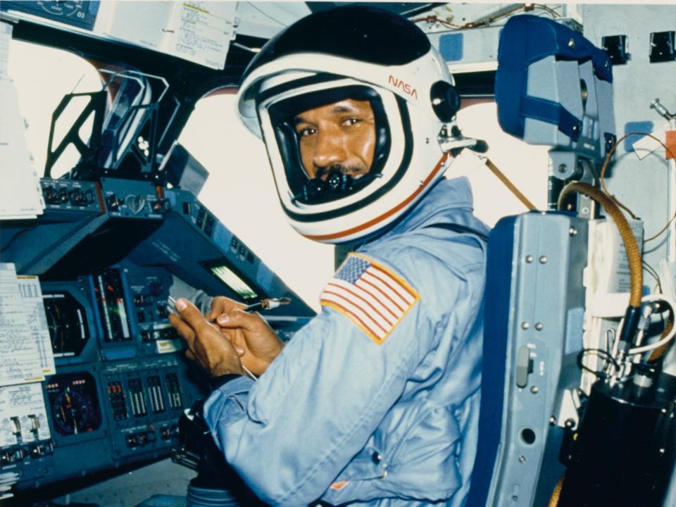 Charles Bolden wears a flight suit and helmet at the pilot's station on the Space Shuttle Columbia