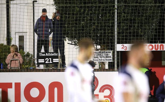 A fan with a Liverpool manager Jurgen Klopp cutout watches the game