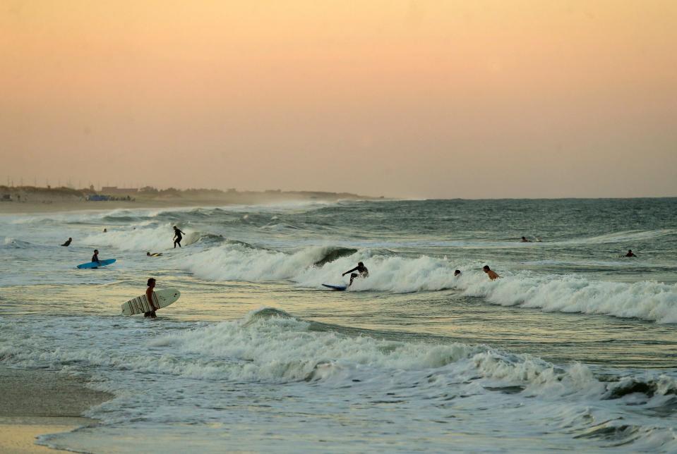 Surfers compete for waves near the Indian River Inlet at the Delaware Seashore State Park in the early evening, Saturday, Sept. 2, 2023 during the unofficial end to summer, Labor Day Weekend.