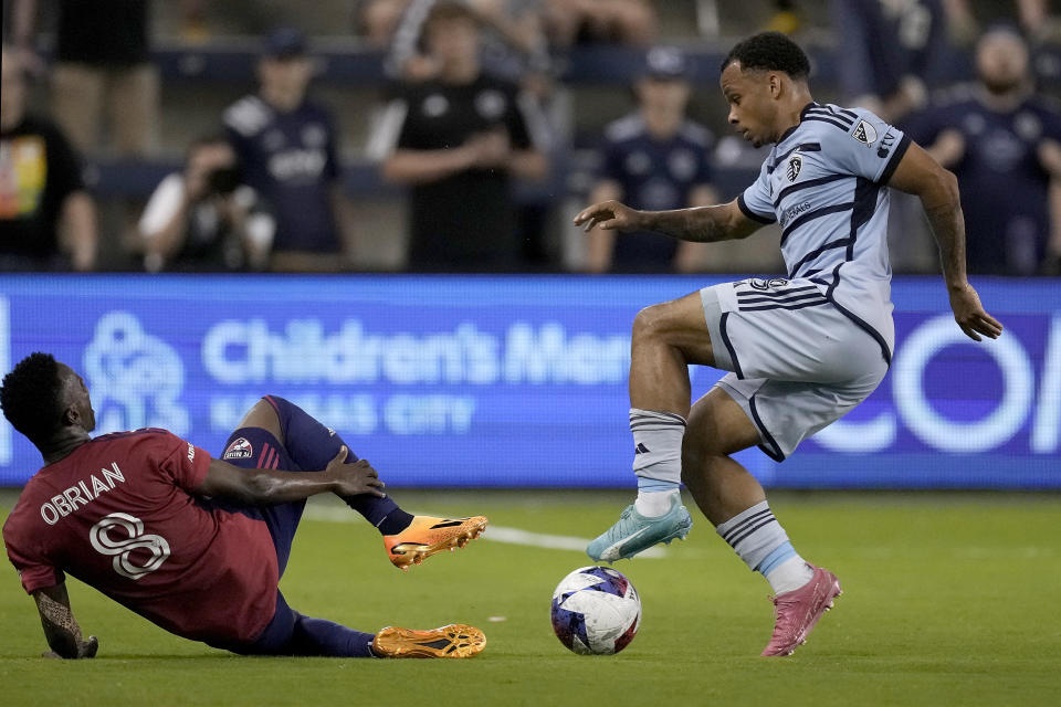 Sporting Kansas City defender Logan Ndenbe, right, and FC Dallas forward Jáder Obrian (8) battle for the ball during the first half of an MLS soccer match Wednesday, May 31, 2023, in Kansas City, Kan. (AP Photo/Charlie Riedel)