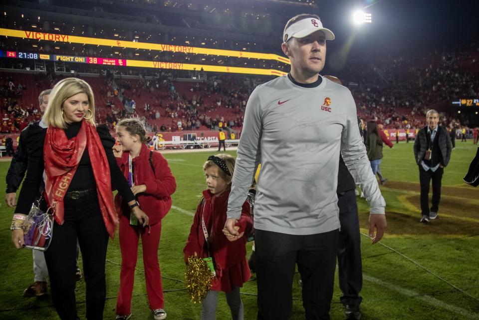 USC coach Lincoln Riley leaves the field with his family after beating Notre Dame at the Coliseum on Nov. 26.