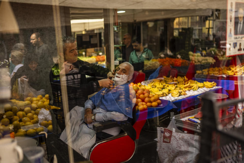 A man has his beard shaved in a barber shop at Balat neighbourhood, in Istanbul, Turkey, Tuesday, March 19, 2024. (AP Photo/Francisco Seco)