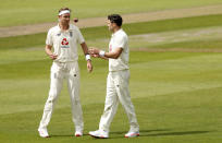 England's Stuart Broad, left, passes the ball to teammate James Anderson during the second day of the first cricket Test match between England and Pakistan at Old Trafford in Manchester, England, Thursday, Aug. 6, 2020. (Lee Smith/Pool via AP)