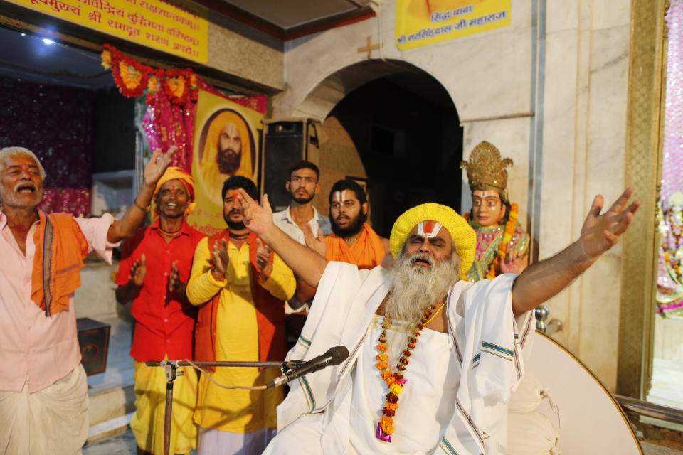 Hindu holy man Shri Narsingh Das Maharaja, right, celebrates after a verdict in a decades-old land title dispute between Muslims and Hindus, in Ayodhya, India, Saturday, Nov. 9, 2019. India's Supreme Court on Saturday ruled in favor of a Hindu temple on a disputed religious ground and ordered that alternative land be given to Muslims to build a mosque. The dispute over land ownership has been one of the country's most contentious issues. (AP Photo/Rajesh Kumar Singh)