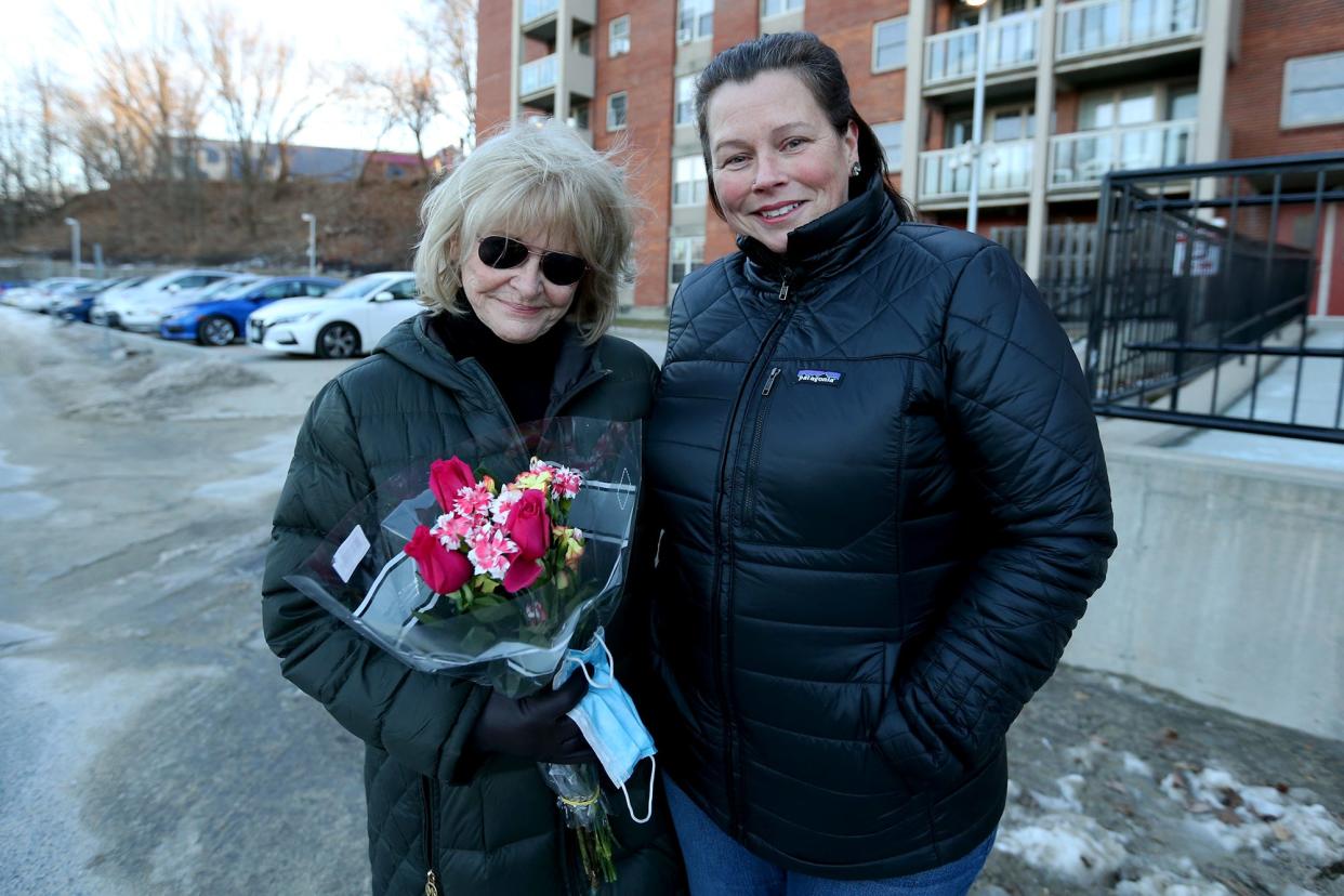 Lori Brown, left, receives flowers from Michelle Cook, the daughter of Gisele Tibbets Thursday, Jan. 20, 2022. Brown is credited with saving Tibbets' life after finding her unconscious Sunday afternoon in Dover.