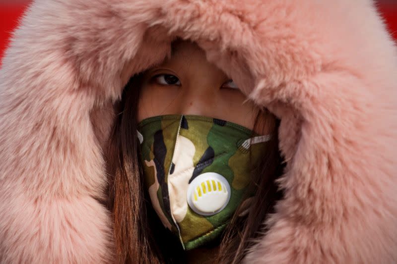 A woman wearing a face mask arrives from Hubei province at a checkpoint at the Jiujiang Yangtze River Bridge in Jiujiang