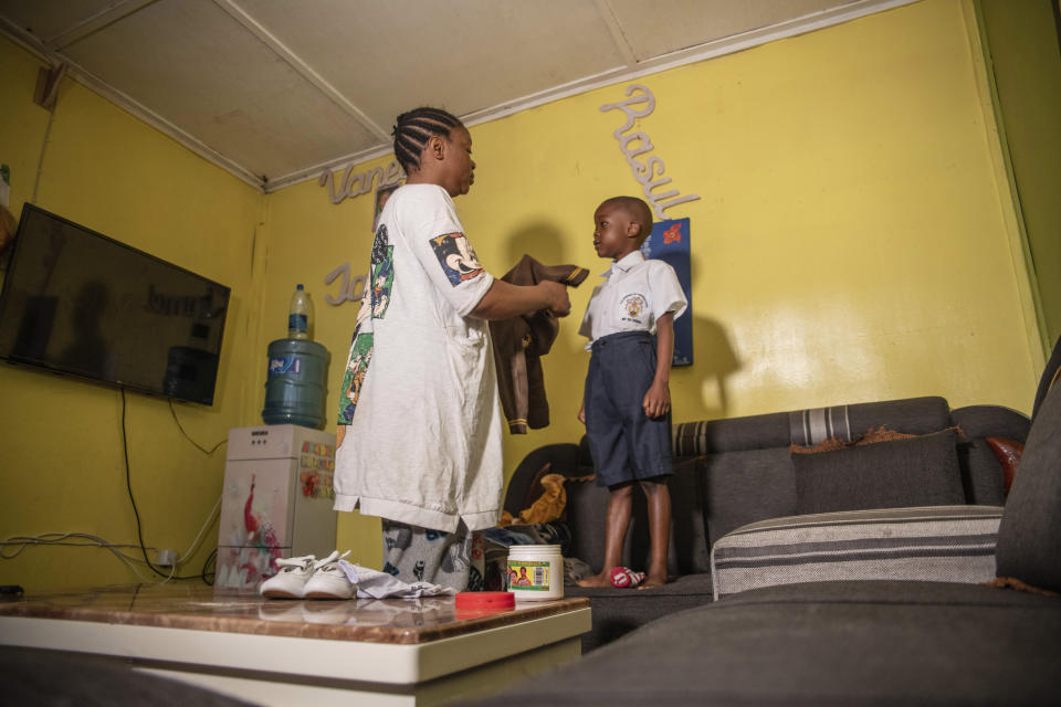 Vanessa Emedy dresses her son before taking him to school in Goma, Democratic Republic of the Congo, Thursday March 30, 2022. The night of Emedy's husband Godefroid Kamana's burial, extended family members came to the family home where Vanessa had just begun her period of mourning. "They didn't wait the 40 days," she lamented. "I was stripped of everything, of all my possessions." (AP Photo/Moses Sawasawa)