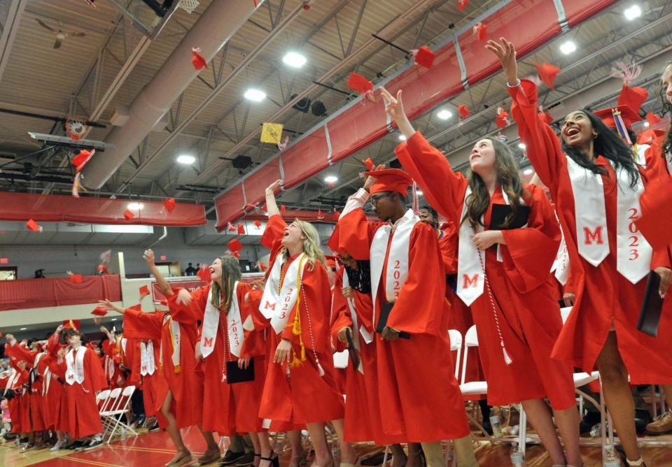 Graduates toss their caps during the Milton High School graduation Sunday.