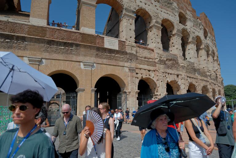 Los turistas se refugian del sol y la ola de calor bajo sombrillas frente al Coliseo en Roma, Italia, el 21 de julio de 2024. (Foto de Massimo Valicchia/NurPhoto vía Getty Images)