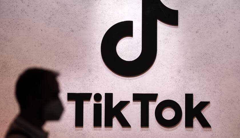 FILE - A visitor passes the TikTok exhibition stands at the Gamescom computer gaming fair in Cologne, Germany, Thursday, Aug. 25, 2022. The European Union's executive arm said Thursday, Feb. 23, 2023 it has temporarily banned TikTok from phones used by employees as a cybersecurity measure, reflecting growing worries from authorities over the Chinese-owned video sharing app. (AP Photo/Martin Meissner, File)