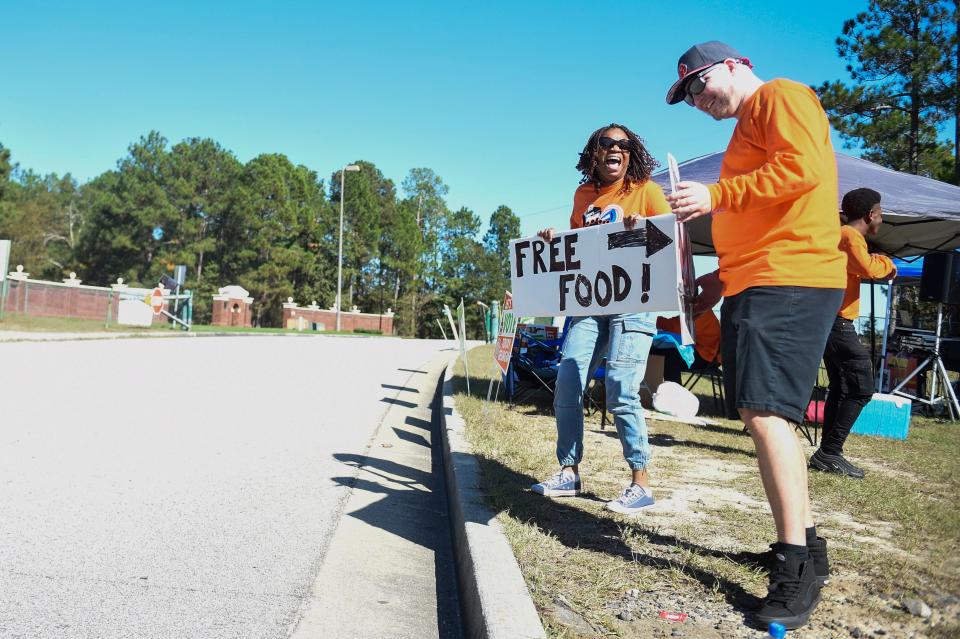 Grovetown Councilwoman Ceretta Smith holds a free food sign with other volunteers as they host a party at the polls at Diamond Lakes on Tuesday, Nov. 8, 2022. 