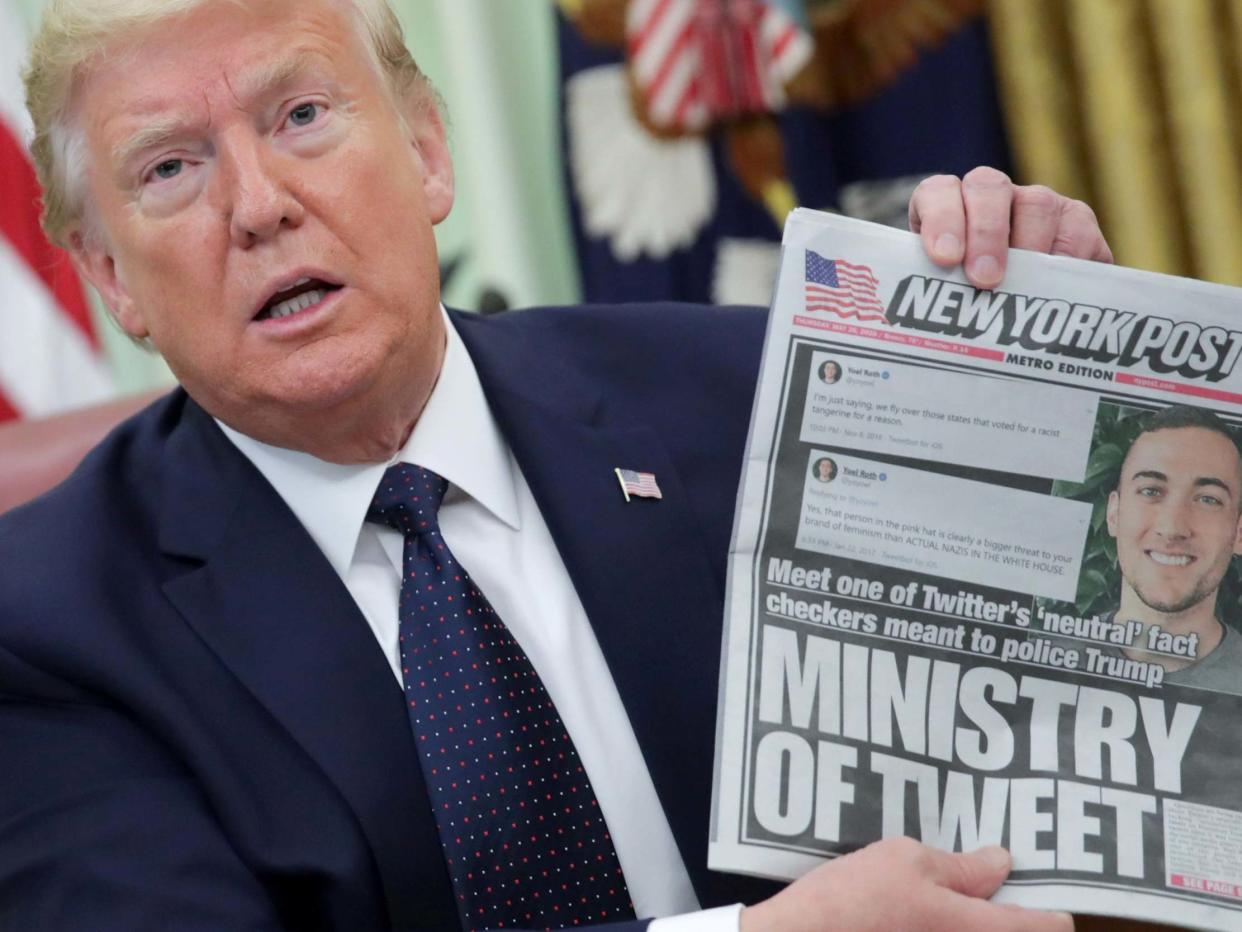 US president Donald Trump holds up a front page of the New York Post as he speaks to reporters while discussing an executive order on social media companies in the Oval Office of the White House in Washington, US, 28 May 2020: Jonathan Ernst/Reuters